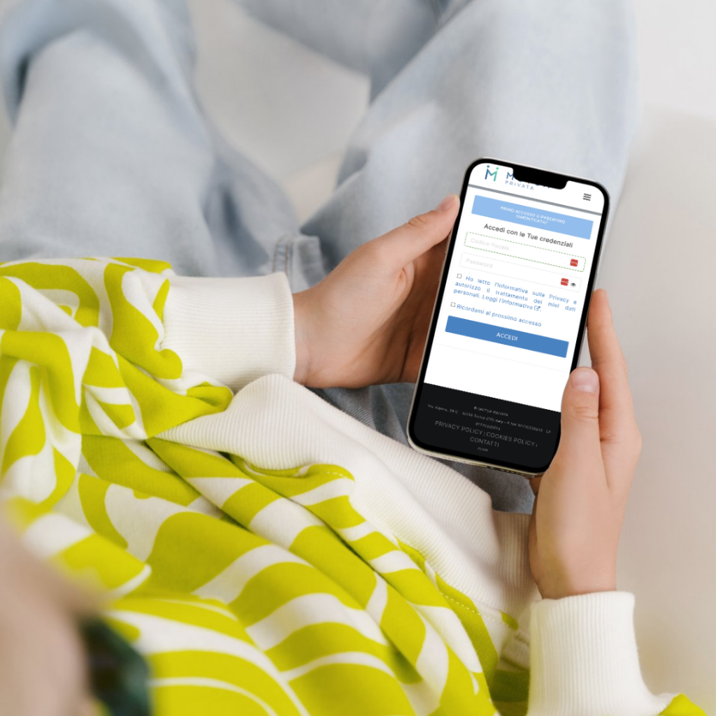 persona seduta tiene in mano uno smartphone. Sta navigando area utente Mutua Privata